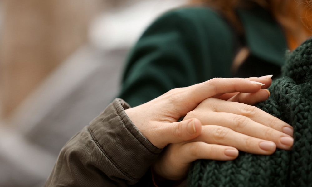 A woman putting her hand on a shoulder