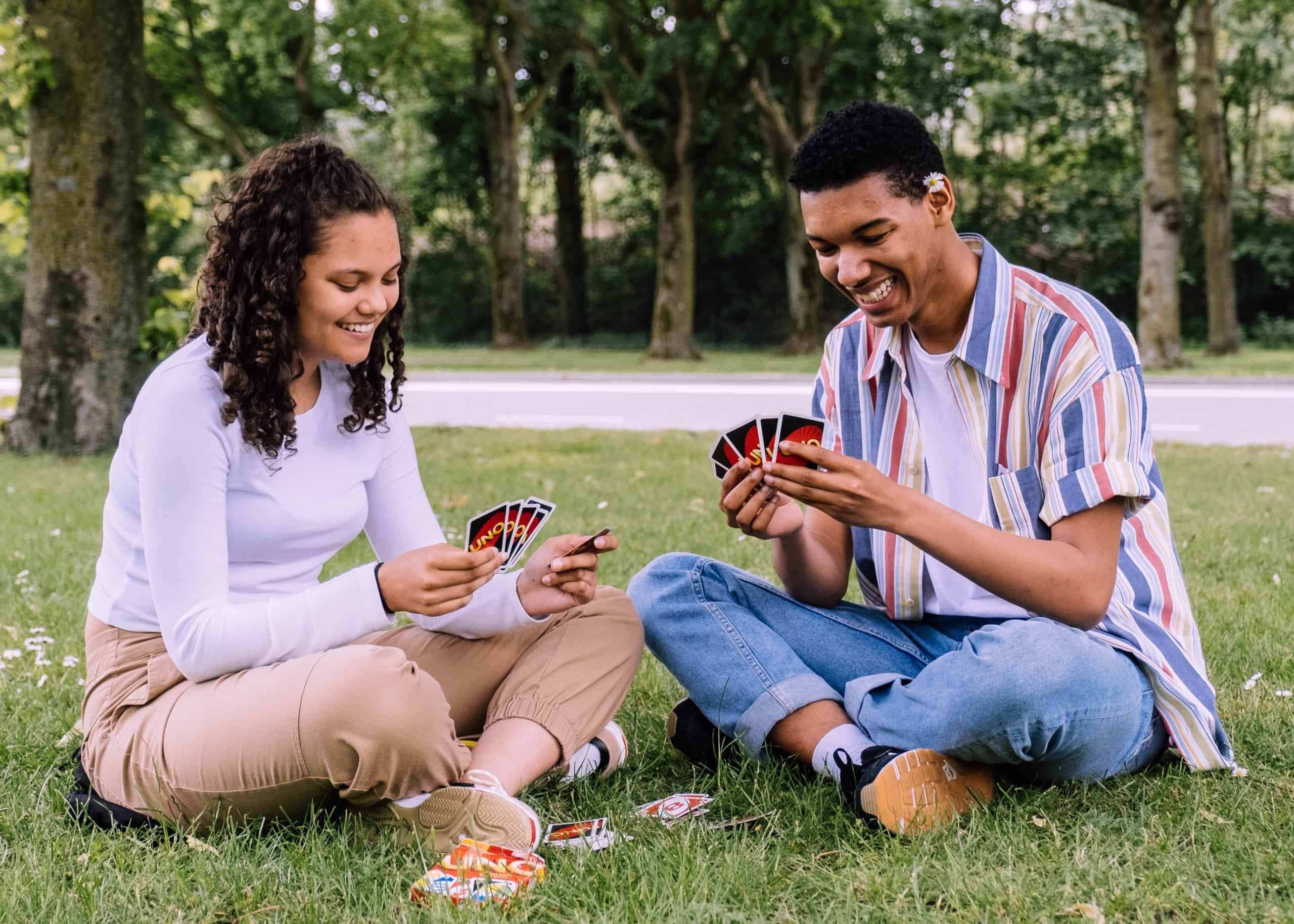 Couple playing cards in the park.