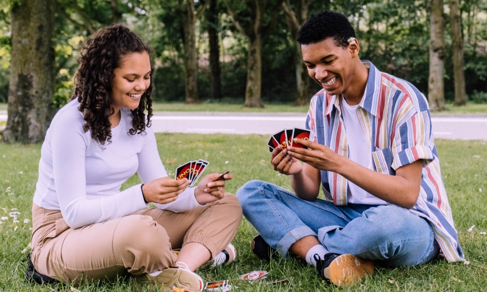 Couple playing cards in the park.