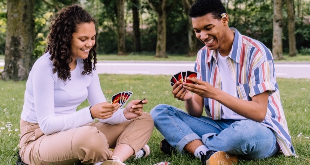 Couple playing cards in the park.